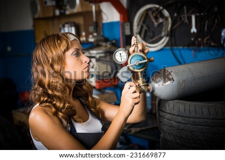 auto service station, working girl. woman in a white headscarf working in the garage