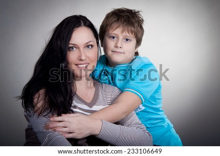 smiling woman with her son in the studio, hugging