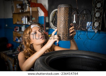 auto service station, the girl in the garage keeps tire. the employee of the garage, working specialty