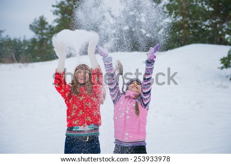 Mother and her little daughter enjoying beautiful winter day outdoors. Mother and daughter outdoors in winter