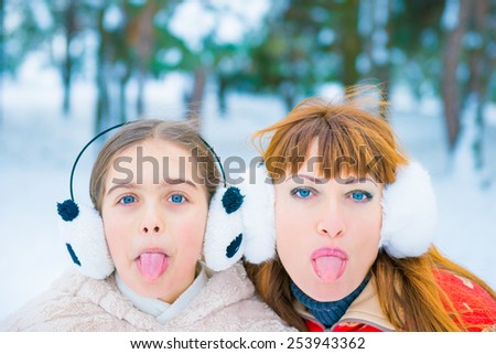 two girls surprised faces on snow background. surprise winter discounts. Mom and daughter in the park in winter, cheerful two girls in the winter forest, two funny portrait in winter