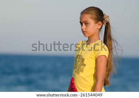 portrait of a beautiful girl at sunset. girl in yellow t-shirt on sky background