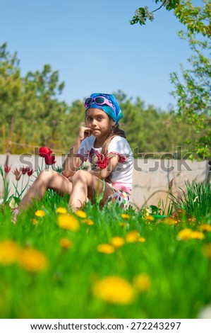 Cute little girl on the meadow in spring day. view of the girl through the grass. preschool girl in the country