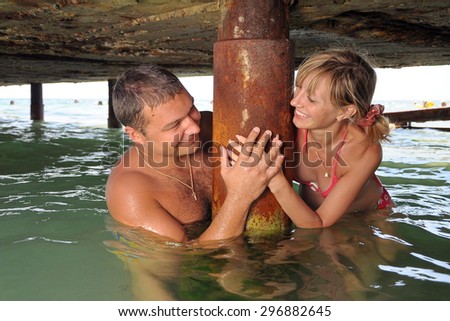 young couple on vacation at sea. man and woman in love. man and woman in the water under the bridge