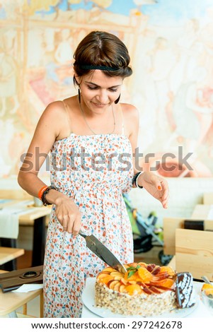 girl cuts the birthday cake. happy young woman with a cake