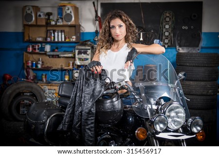 beautiful girl sitting on a motorcycle in the garage. slight blur