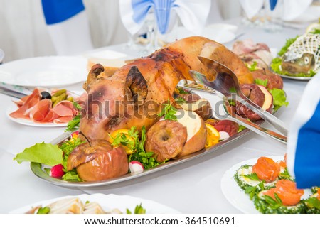 Roast pig. roasted piglet with vegetables on platter
