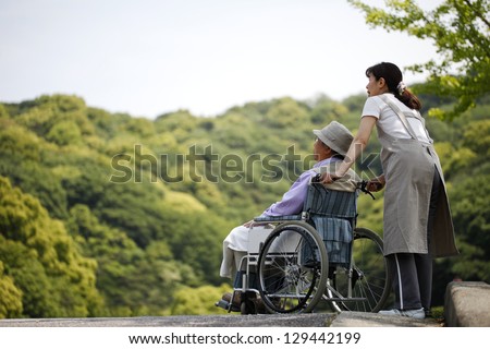 Senior in a wheelchair and helper
