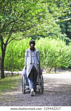 Senior in a wheelchair and helper
