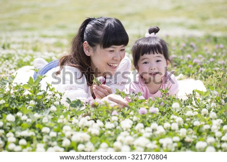 Mother and daughter playing in the spring meadow