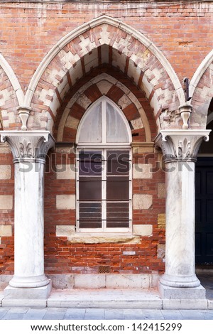 Arched window in brick building surrounded by columns