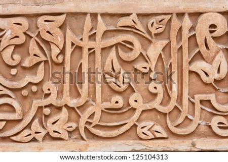 carved stone with arabic script and symbols