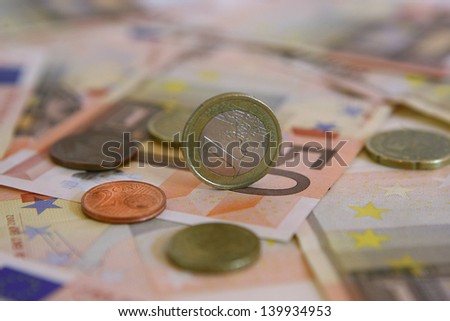 euro coins on fifty euro banknotes background.focus on one euro coin