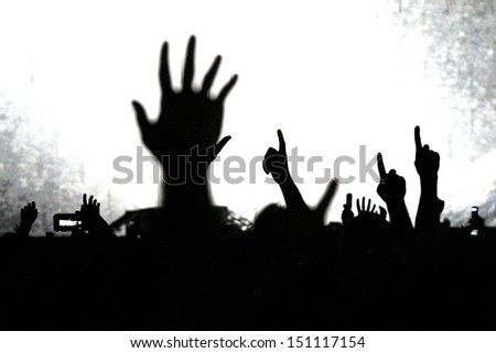 cheering crowd at a rock concert.silhouettes of hands up