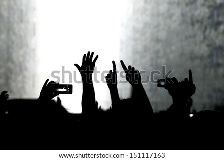 cheering crowd at a rock concert.silhouettes of hands up