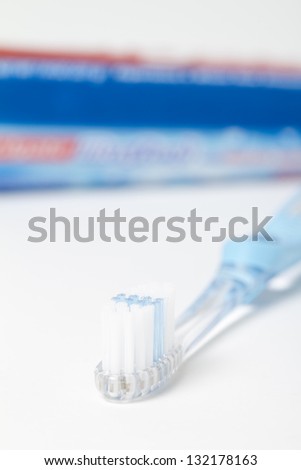 Toothbrush and Tube in Background Focus on head of toothbrush. in the background is a out of focus toothpaste tube.