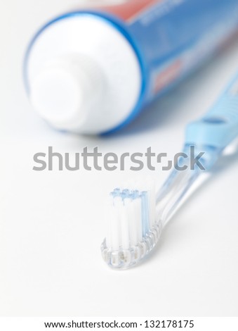 Toothbrush with Toothpaste Tube Front Macro shot of a toothbrush with a tube of toothpaste in the background. shot on white