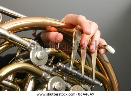 French horn being played, fingers moving