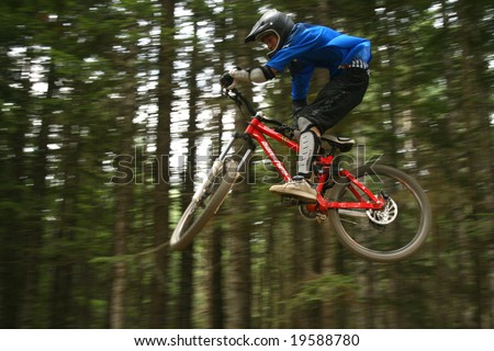 WHISTLER, BC - AUG 15, 2008: Amateur Rider pulls a trick off a jump on A-line, one of the most popular trails  at Crankworx Festival