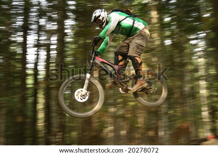 WHISTLER, BC - AUG 15, 2008: Amateur Rider pulls a trick off a jump on A-line, one of the most popular trails at Crankworx Festival