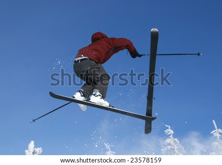 Skier jumping with a ski coming off mid-air