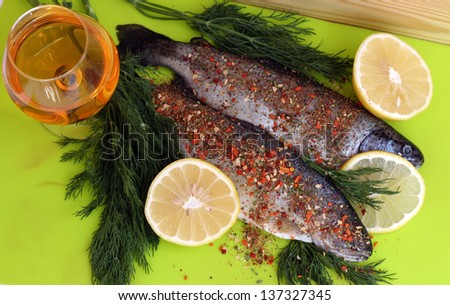 two rainbow trouts with lemon, apple juice and dill ready to cook
