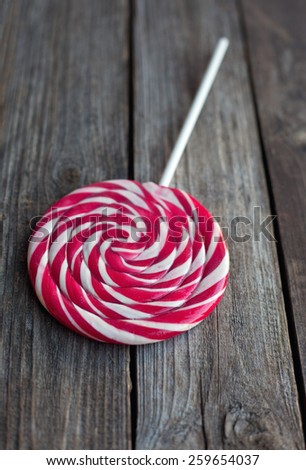red and white sweet lollipop on wooden rustic table