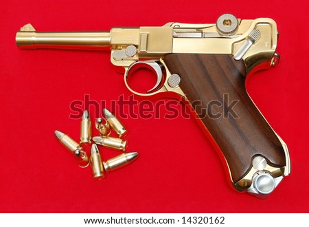 Golden gun isolated over a red background