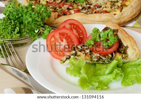Pie with spinach and cheese served with salad and tomatoes