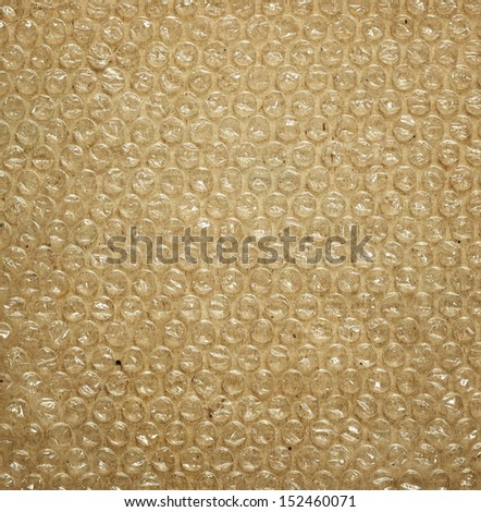 Plastic bubble packaging material on brown background