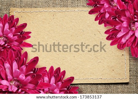 Paper card and aster flowers on beige canvas background