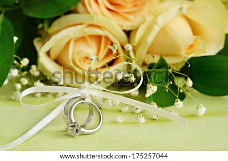 Engagement and wedding rings with bouquet of flowers