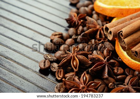 Fragrant spices, coffee and dry orange on a wooden background