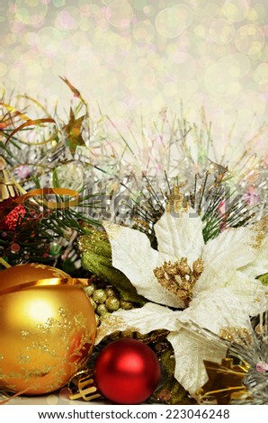 Christmas balls with tinsel and artificial poinsettia on a holiday background
