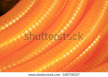 orange plastic pipe stacked toghter at a construction site