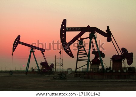 crank balanced beam pumping unit under the curtain of night in the JiDong oilfield, on December 1, 2013, caofeidian, hebei province, China.
