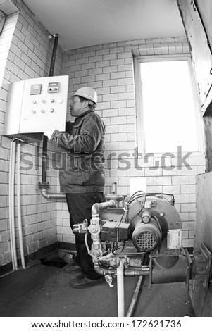 TANGSHAN - DECEMBER 20 Technical personnel adjustment automatic gas type control device, in a manufacturing enterprise, on December 20, 2013, tangshan city, hebei province, China.