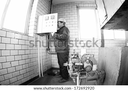 TANGSHAN - DECEMBER 20: Technical personnel adjustment automatic gas type control device, in a manufacturing enterprise, on December 20, 2013, tangshan city, hebei province, China.province, China.