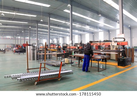 TANGSHAN - DECEMBER 22: Worker in operating machinery on the production line, in a solar equipment production workshop on december 22, 2013, tangshan, china.