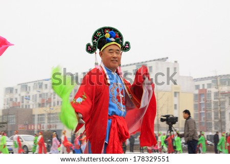 LUANNAN COUNTY - FEBRUARY 8: An old man wearing colorful clothes, performing yangko dance in the street, during the Chinese Lunar New Year, February 8, 2014, Luannan County, Hebei Province, China.