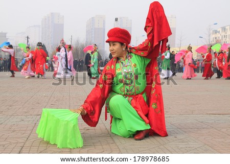 LUANNAN COUNTY - FEBRUARY 15: Old woman wearing colorful clothes, performing yangko dance in the street, during the Chinese Lunar New Year, February 15, 2014, Luannan County, Hebei Province, China.