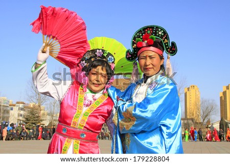 LUANNAN COUNTY, CHINA - FEBRUARY 9: People wearing colorful clothes, performing yangko dance in the street, during the Chinese Lunar New Year, February 9, 2014, Luannan County, Hebei Province, China.