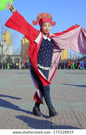 LUANNAN COUNTY, CHINA - FEBRUARY 9: Girl wearing colorful clothes, performing yangko dance in the street, during the Chinese Lunar New Year, February 9, 2014, Luannan County, Hebei Province, China.