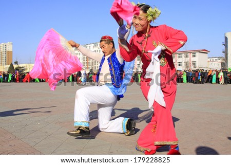 LUANNAN COUNTY, CHINA - FEBRUARY 10: People wearing colorful clothes, performing yangko dance in the street, during the Chinese Lunar New Year, February 10, 2014, Luannan County, Hebei Province, China.
