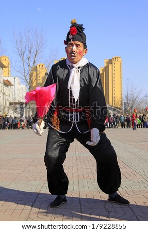 LUANNAN COUNTY, CHINA - FEBRUARY 9: Clown wearing black clothes, performing yangko dance in the street, during the Chinese Lunar New Year, February 9, 2014, Luannan County, Hebei Province, China.
