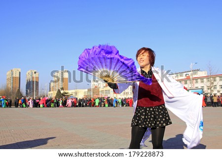 LUANNAN COUNTY, CHINA - FEBRUARY 10: People wearing colorful clothes, performing yangko dance in the street, during the Chinese Lunar New Year, February 10, 2014, Luannan County, Hebei Province, China.