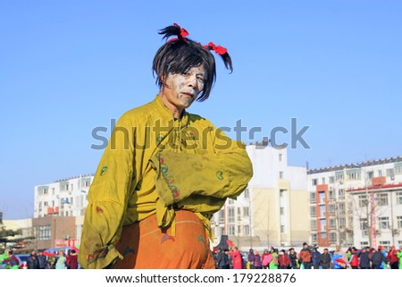 LUANNAN COUNTY, CHINA - FEBRUARY 10: Buffoon wearing colorful clothes, performing yangko dance in the street, during the Chinese Lunar New Year, February 10, 2014, Luannan County, Hebei Province, China.