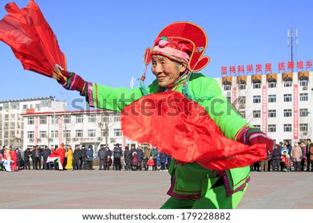 LUANNAN COUNTY, CHINA - FEBRUARY 9: People wearing colorful clothes, performing yangko dance in the street, during the Chinese Lunar New Year, February 9, 2014, Luannan County, Hebei Province, China.