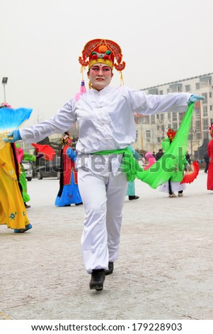 LUANNAN COUNTY, CHINA - FEBRUARY 8: People wearing colorful clothes, performing yangko dance in the street, during the Chinese Lunar New Year, February 8, 2014, Luannan County, Hebei Province, China.