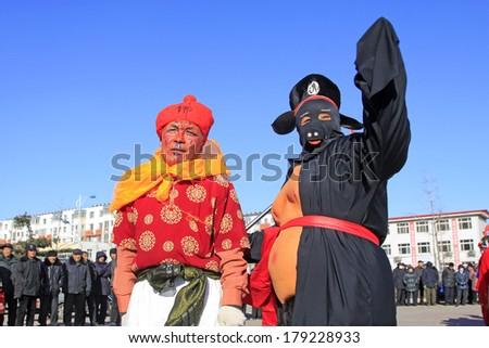 LUANNAN COUNTY, CHINA - FEBRUARY 9: Monkey King and Zhubajie wearing colorful clothes, performing yangko dance in the street, February 9, 2014, Luannan County, Hebei Province, China.
